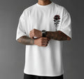 Person wearing a white t-shirt with a rose design and 'California' text on a gray background